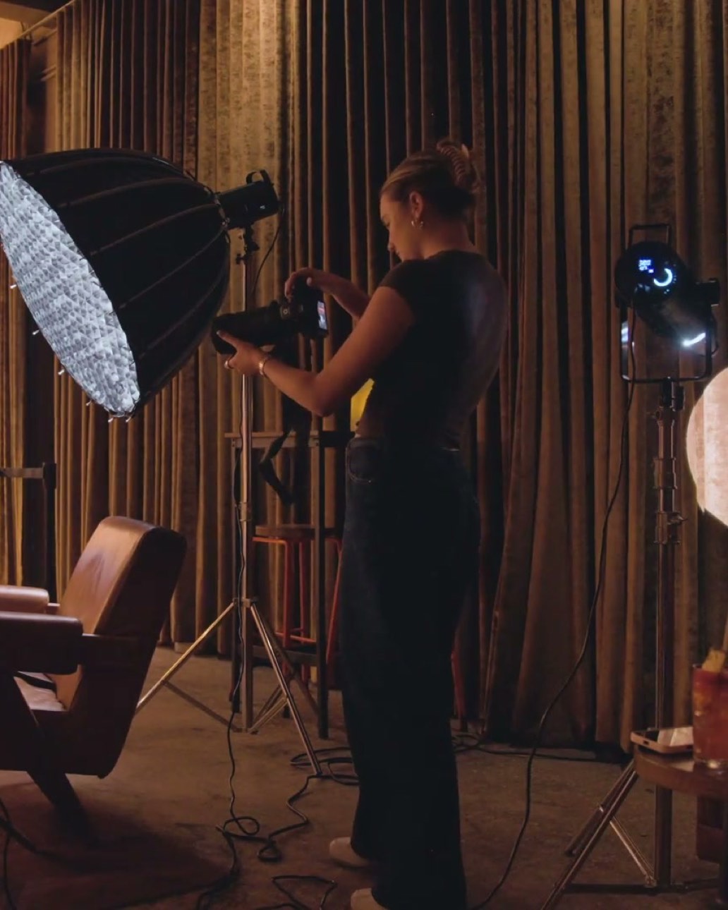 Behind the scenes at Dante's HiFi. A BLANK shooter frames up beside a softbox in the gold curtained room.